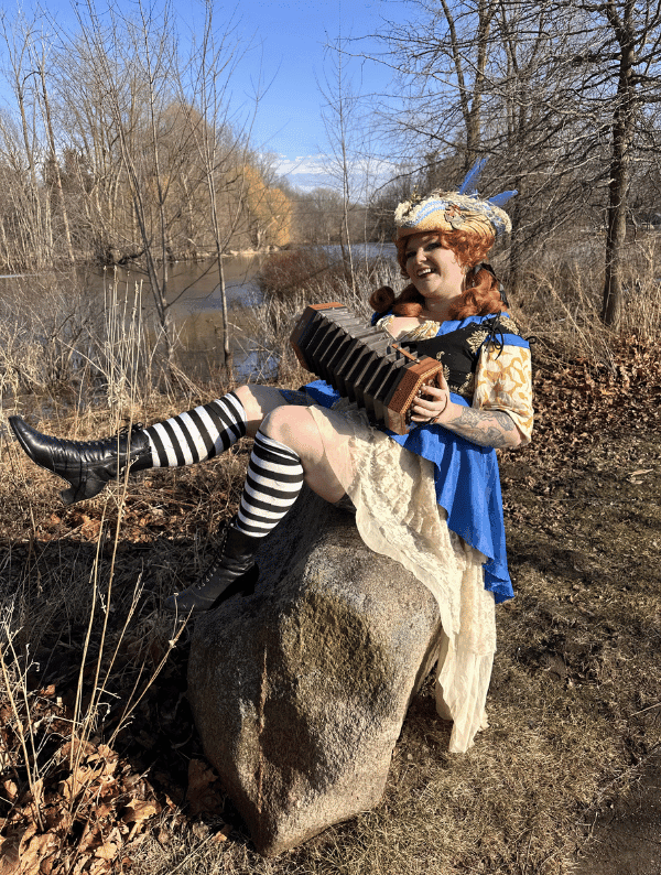 Captain Shh-nel in full Renaissance pirate costume with ornate tricorn hat, holding a plunger with theatrical flair